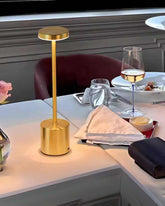 Gold LumiHikari Scandinavian Lamp with minimalist design on a dining table with wine glass and dinner setting
