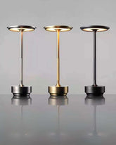 Three LumiHikari Base Lamps in brushed metal finishes showcasing cool, warm, and mixed ambient lighting modes on a reflective surface